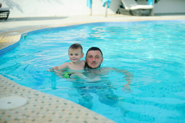 Dad and son swim in the pool