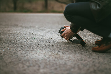 Young photographer guy is engaged in macro photography of ants on asphalt. Free space for text