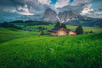 Obraz premium Wooden huts on the slope in the Dolomites, Italy