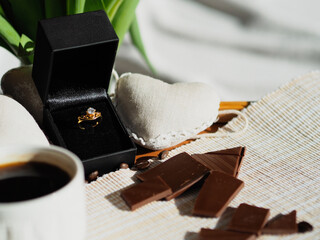 Gold ring, chocolate and a cup of morning coffee 
