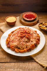 Masfouf from couscous on almond milk with dried fruits and nuts on a wooden table next to saffron and milk.