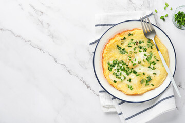 Omelette or frittatas with green onions or young greenery and mozzarella on white marble table...