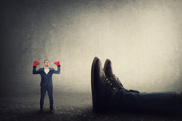 Businessman with boxing gloves celebrates victory in a fight against his giant boss. Office...