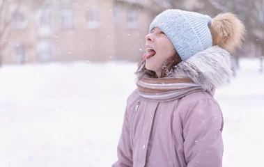 Fototapete Süße Monster Fröhlicher Wintertag. Kleines Mädchen, das Schneeflocken isst. Kind, das draußen spielt und Schnee genießt.