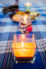 candles and healthy food and fruits on a blue checkered tablecloth