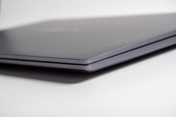 Close-up of a gray modern laptop. Side view, closed laptop. Selective focus. The concept of devices for work and leisure