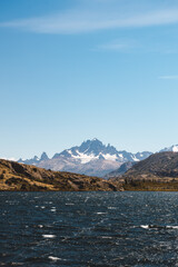 Large mountain range behind a navy blue lake. Patagonian landscape.