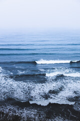 Waves of a blue sea breaking on the shore of the beach