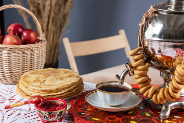 Russian pancakes blini with samovar tea cup and drying on the table. Shrovetide Maslenitsa festival...