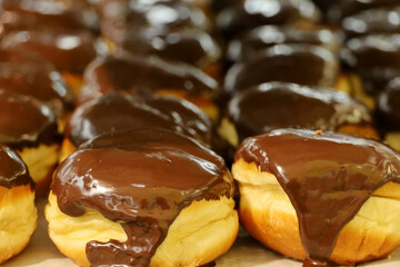 Doughnuts in in chocolate sauce close up. Sweet donuts in a store, high calorie food