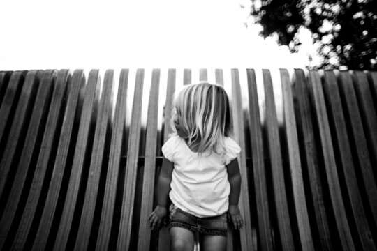 mysterious portrait of young girl against wood slats.