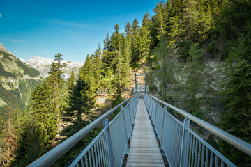 Fototapeta Suspension bridge on Bisse du Ro walking trail near Crans Montana in canton of Valais obraz