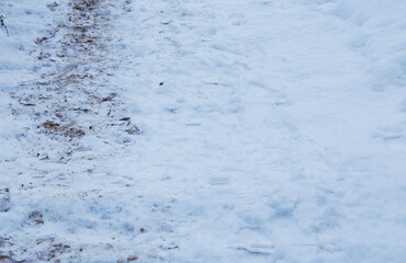 Stairs covered in snow with footprints and dirt.