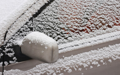 A gray car window covered with snow.