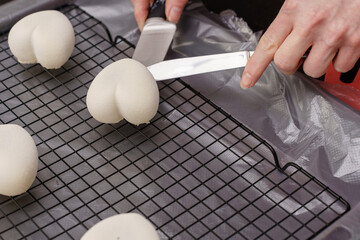 a female pastry chef prepares white mousse cakes in kitchen