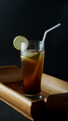 Lemon tea is a refreshing drink served on a bamboo tray, black background
