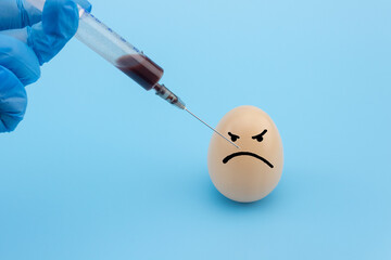The syringe is injected into the egg. Scientific experiment