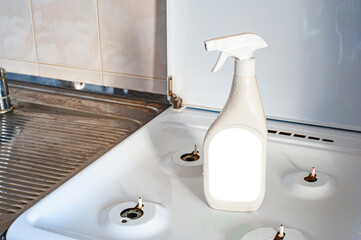 A cleaning agent with a place to insert text, standing on a washed, clean, kitchen stove.