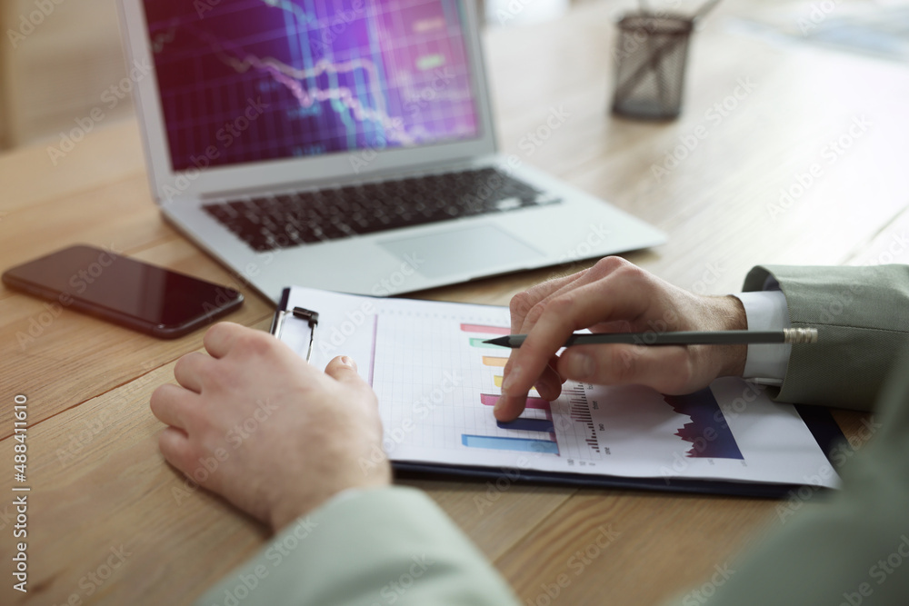 Poster forex trader with chart working in office, closeup