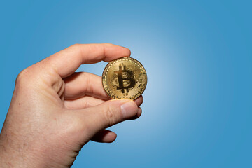 Cryptocurrency coins in a hand; Bitcoin, digital transactions