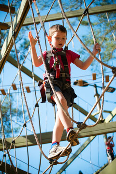 Young Boy Navigating Treetop Ropes Course