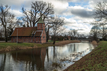 An old church on the banks of the Motława River in Wróblewo  - obrazy, fototapety, plakaty