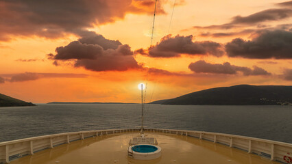 Navire de croisière en navigation. Vue de la proue avec un coucher de soleil.