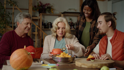  Grandmother tries to carefully cut off the top of the pumpkin and communicates with her grandson and husband