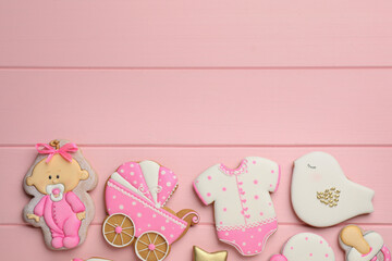 Cute tasty cookies of different shapes and space for text on pink wooden table, flat lay. Baby shower party