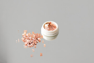 Glitter for nails and body.Beautiful glitter for nails and body close-up. Gold glitter on gray background
