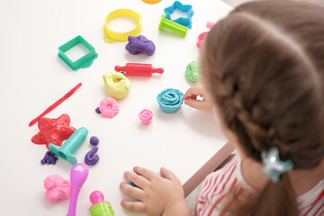 baby girl playing with plasticine, play dough, playdough, mass for modeling, set for creativity