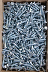 metal bolts in a cardboard box. view from above