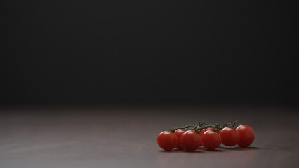 cherry tomatoes on a bracnh on wood table
