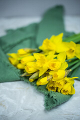 Narzissen auf grünem Stoff, Blumenstrauß Frühling mit gelben Blumen
