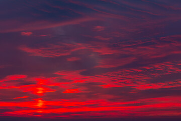 Sunset layers of clods with shades of red, yellow dark blue light gray mutable shapes beautiful sky horizontal photo, photograph just after sunset