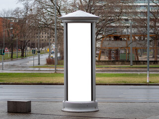 Advertising column in the city. Blank mockup for testing ad designs on the pillar next to the...