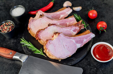 smoked pork steaks on the bone on a stone background