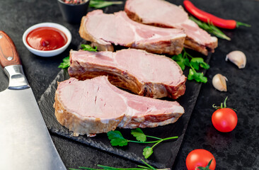 smoked pork steaks on the bone on a stone background