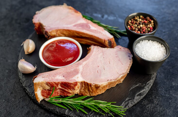 smoked pork steaks on the bone on a stone background