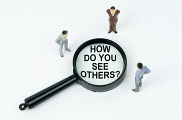 On a white background, figures of businessmen and a magnifying glass with the inscription - HOW DO YOU SEE OTHERS