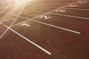 Starting and finishing lines on a running track, including track numbering. Red tartan and white colors.