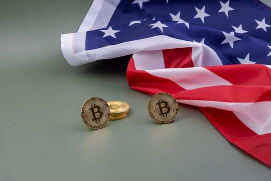 U.S. flag and next to it some bitcoins, on a green table. 