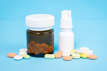drug bottle with pills and colored pills on a blue background