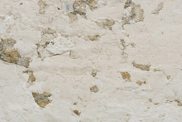 Light background with old cracked plaster. Cracks on the wall.