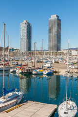 Barcelona towers captured during a sunny day between boats. Barcelona olympic port.