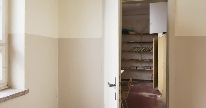 The camera moves into an abandoned small school library, the school is empty since 1995 above you can see the former school books
