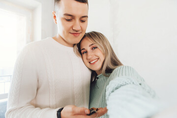 Man and woman buy new flat. Couple hold keys with house keychain. Couple just receiving house key