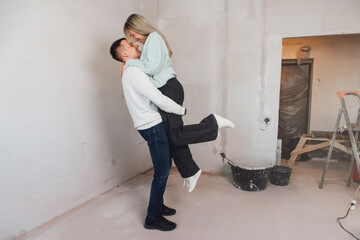 Couple in unfinished building. Woman and men dreaming about apartment renovation. Young couple in new property. Family buy new flat. Strat a new life