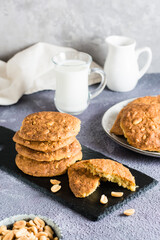 Fresh peanut cookies on a slate and in a plate on the table. Homemade pastries. Vertical view.