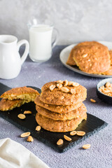 A stack of ready-to-eat fresh peanut cookies on a slate on a table. Homemade pastries. Vertical view